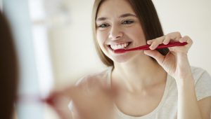 Mulher escovando os dentes feliz