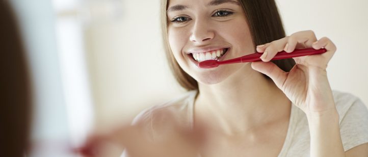 Mulher escovando os dentes feliz